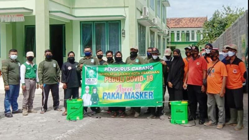 PCNU Kota Kraksaan Giat Semprotkan Disinfektan dan Bagikan Masker ke Warga