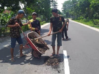 Banser Pakel Tulungagung Tutup Lubang Jalan yang Rusak karena Air Hujan