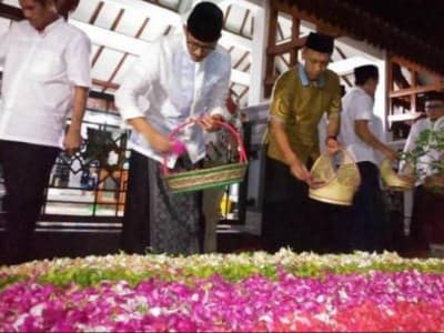 Menyiram Air dan Karangan Bunga di Kuburan