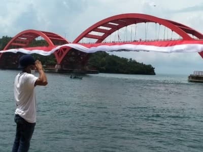 Bersinergi dengan Warga Papua, Banser Bentangkan Bendera di Jembatan Merah Youtefa
