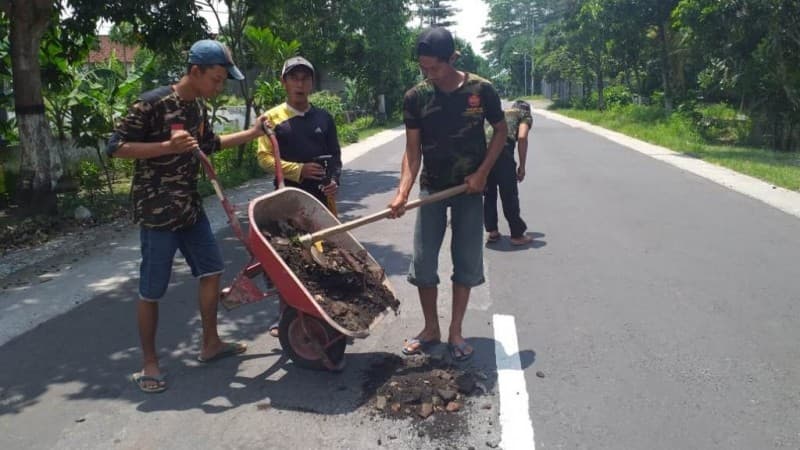 Banser Pakel Tulungagung Tutup Lubang Jalan yang Rusak karena Air Hujan